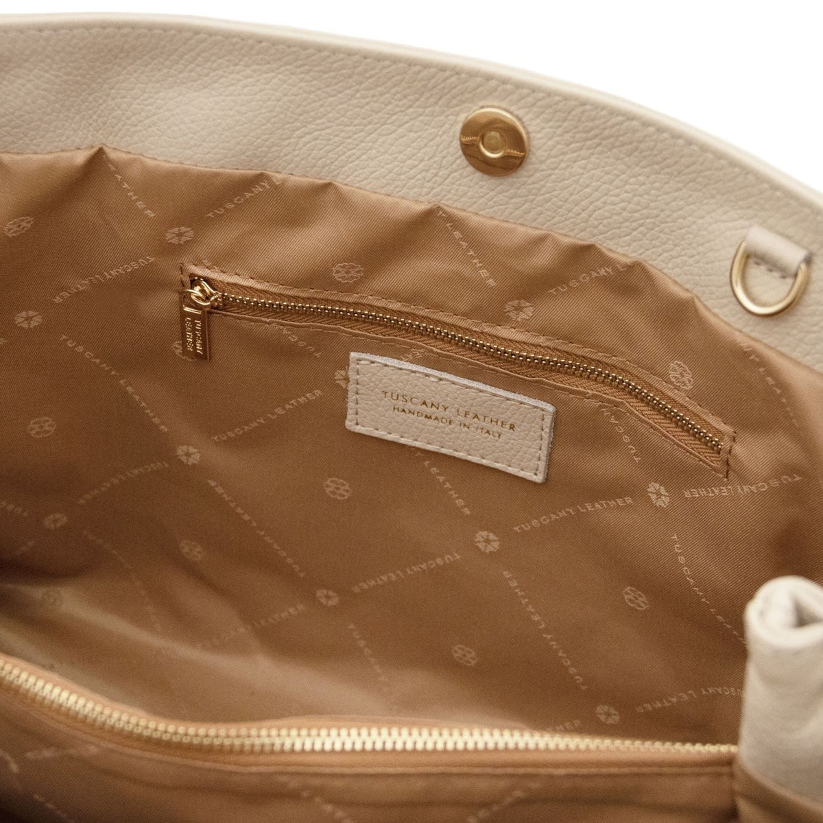 Tan interior lining of Callie soft leather shoulder bag with zip pocket and brand tag