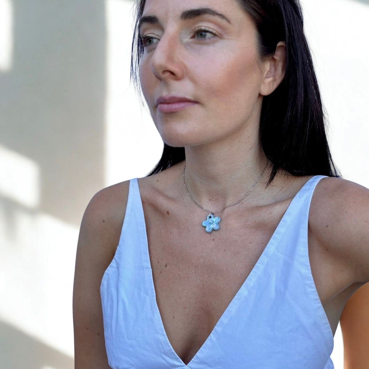 Primo piano of a donna con a hecrafted pearl azzurro floral ceramic pendant necklace