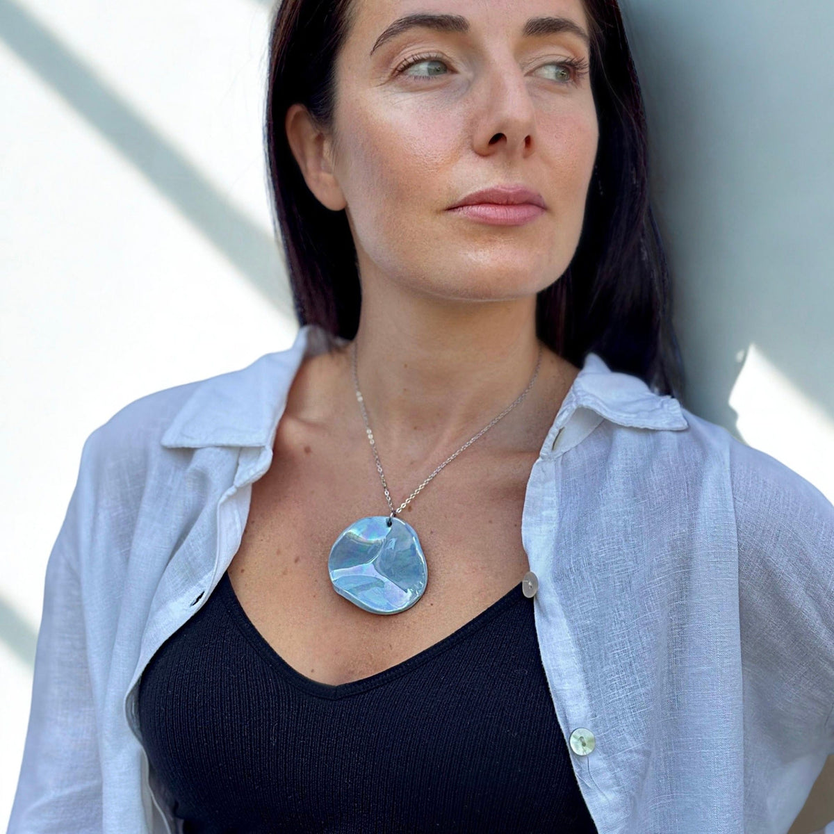 Primo piano of modella con Perla azzurro ceramic pendant necklace con silver chain