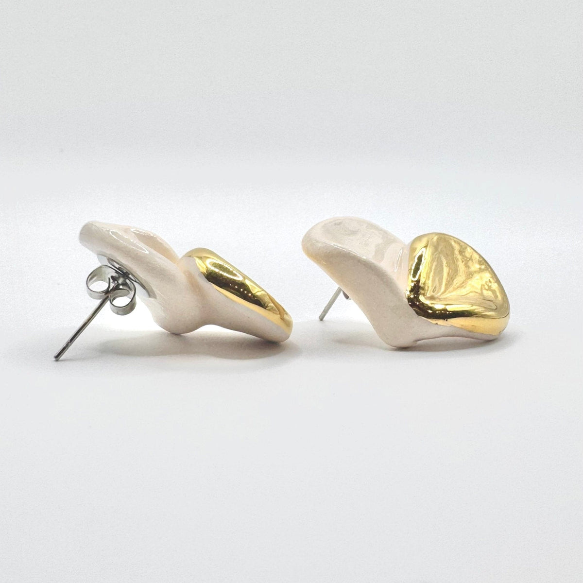 Back view of Petali white pendientes de botón de cerámica with lustre dorado mostrando postes