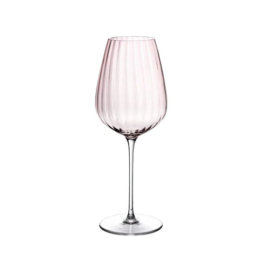 Copa de vino blanco acanalada rosa empolvado con tallo largo y fino sobre fondo blanco