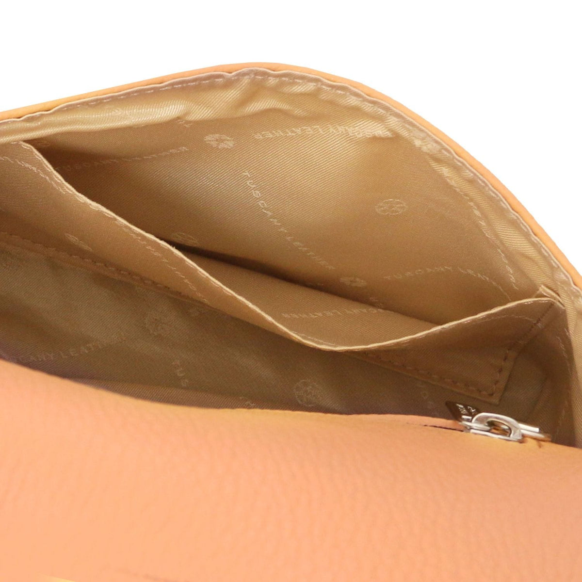 Binnenaanzicht of cognac leather foldover clutch with stitched pockets and beige voering.