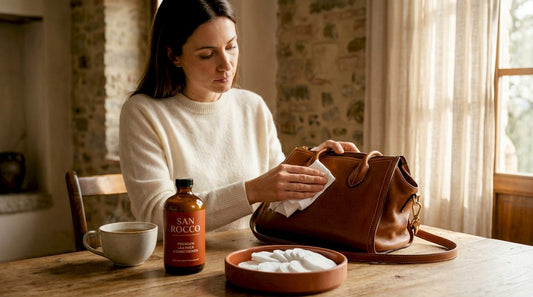 Woman cleaning luxury leather handbag at home