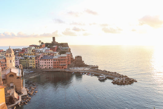 Vista ao pôr do sol de uma colorida aldeia costeira italiana com porto e barcos.