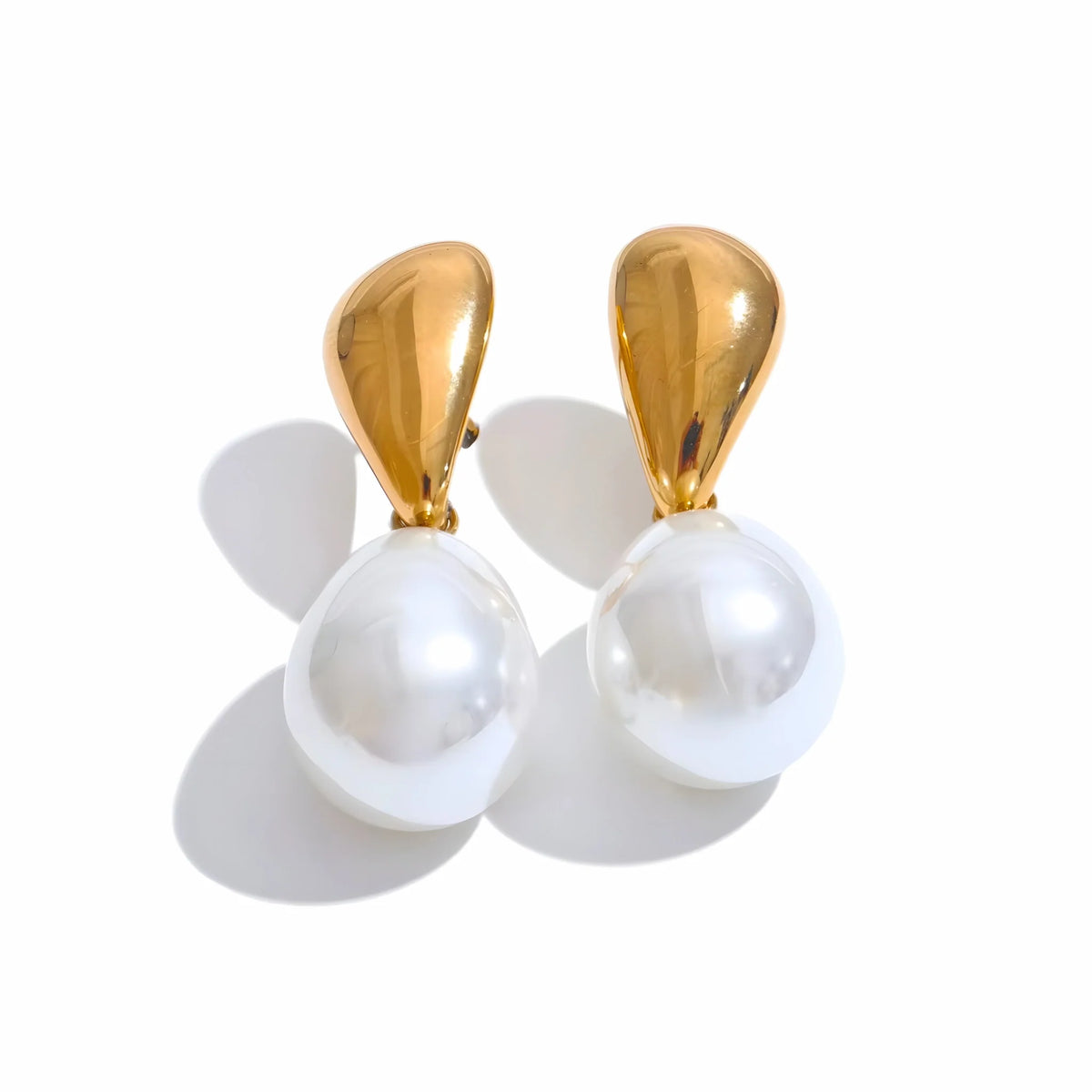 Pair of earrings with gold tops and white pearls sur fond blanc