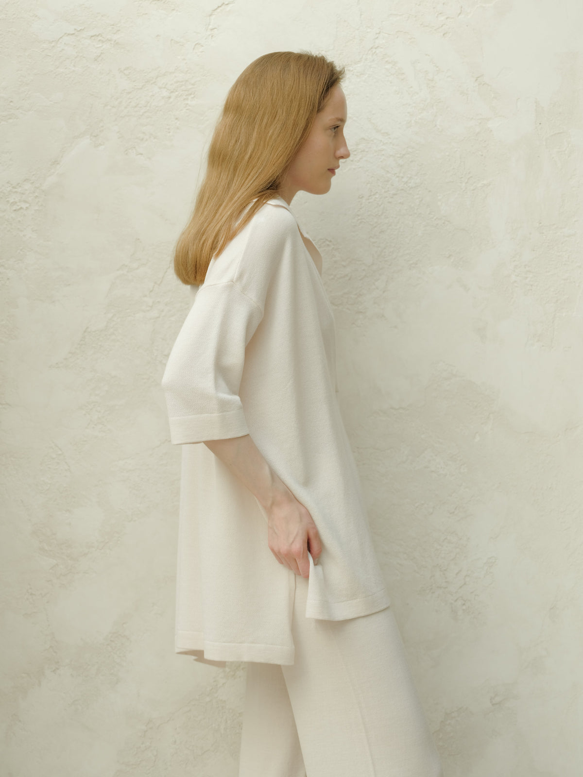 Side profile of a mannequin portant an oversized off white Maxi polo en laine mérinos extrafine with three quarter sleeves.