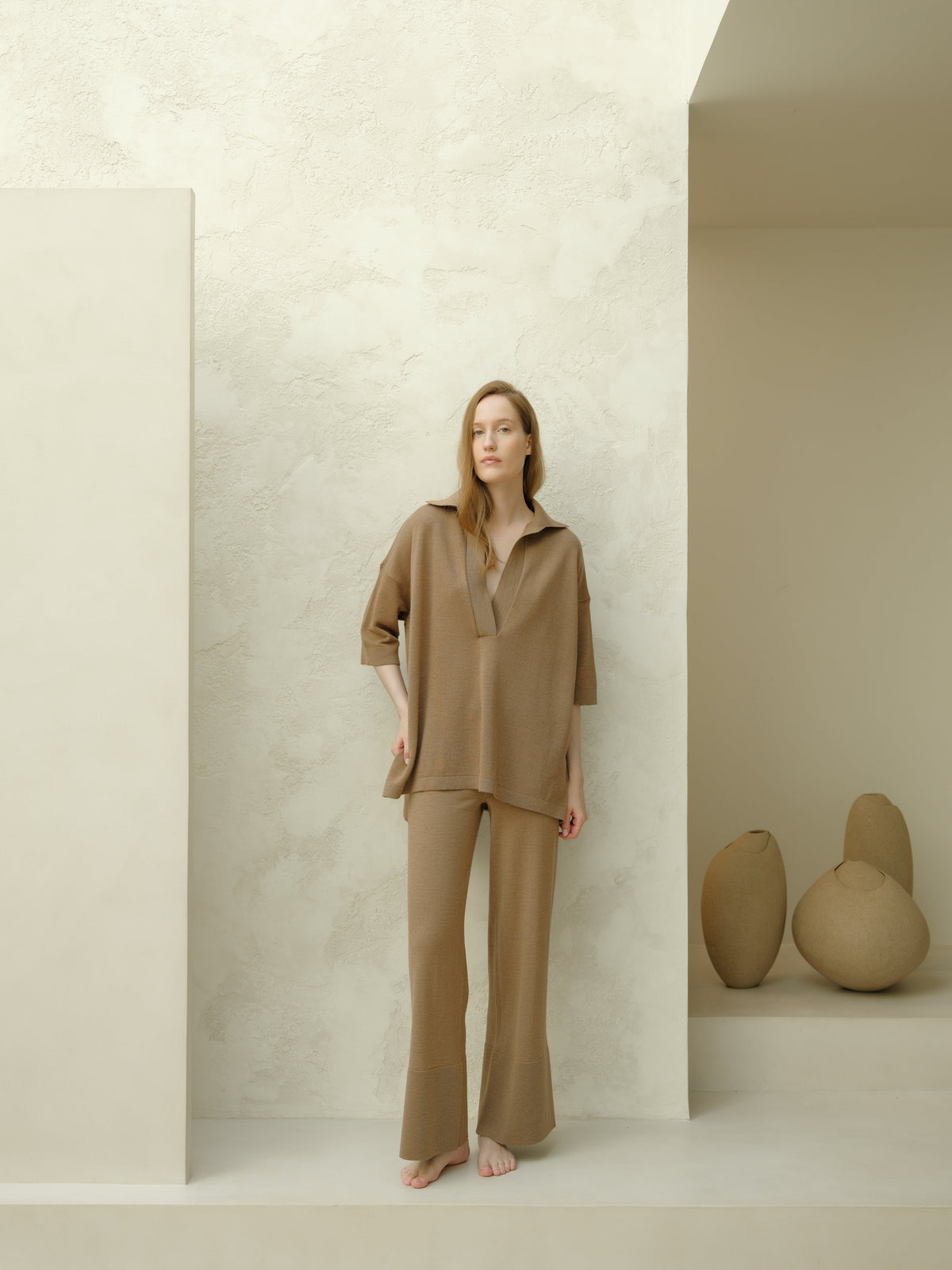 Mannequin portant taupe Maxi polo en laine mérinos extrafine set with an oversized top featuring three-quarter sleeves and pantalon large.