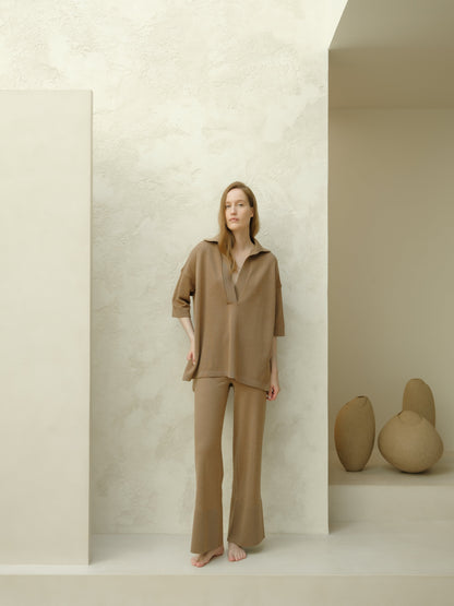 Mannequin portant taupe Maxi polo en laine mérinos extrafine set with an oversized top featuring three-quarter sleeves and pantalon large.