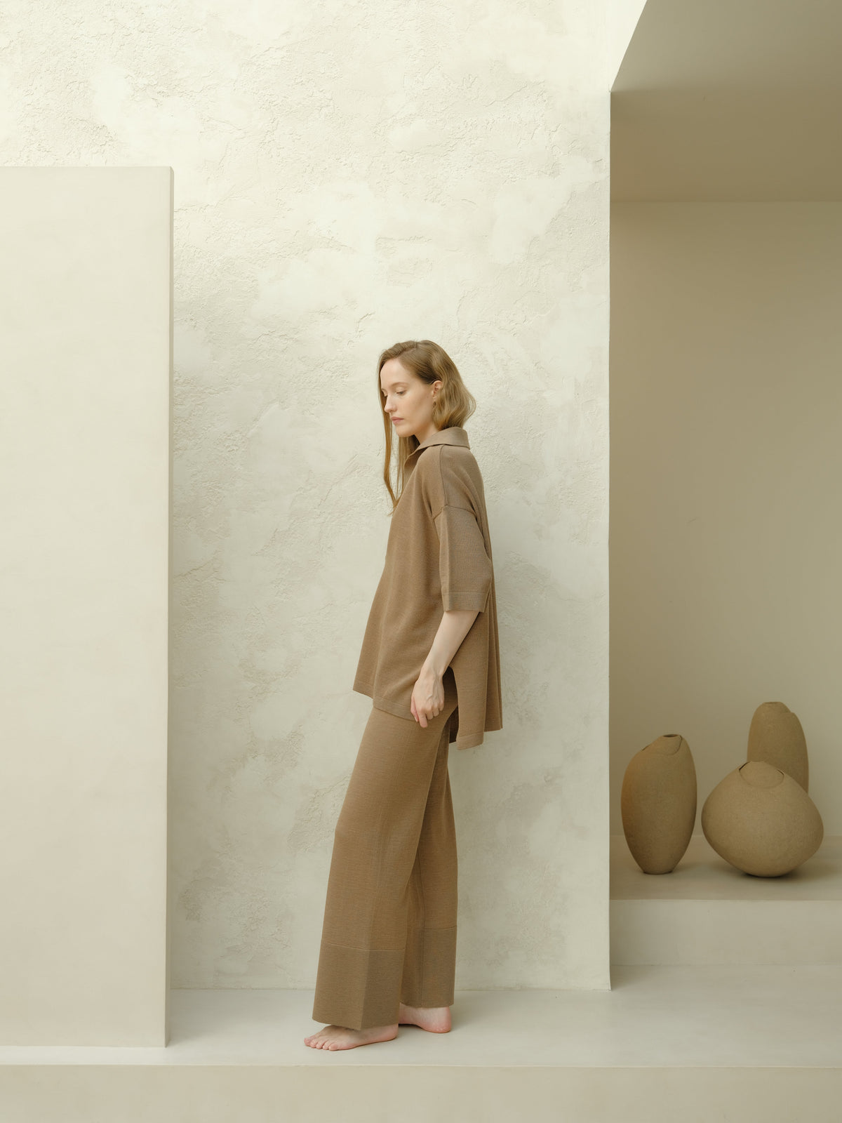Side view of a model in taupe Maxi polo en laine mérinos extrafine set, loose top with three-quarter sleeves and matching wide pants.