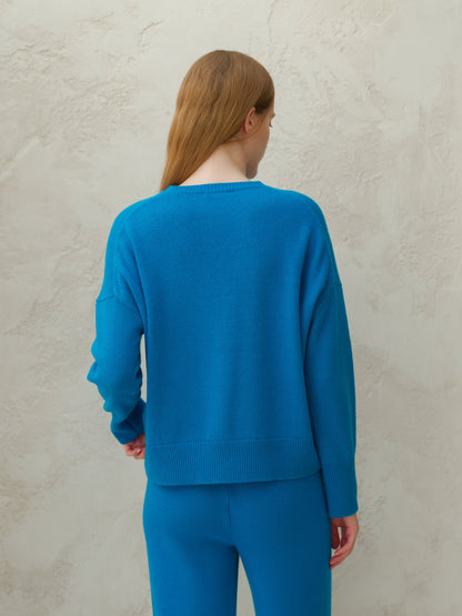 Back view of a modella con a bright blu cashmere mix maglione girocollo con pantaloni coordinati