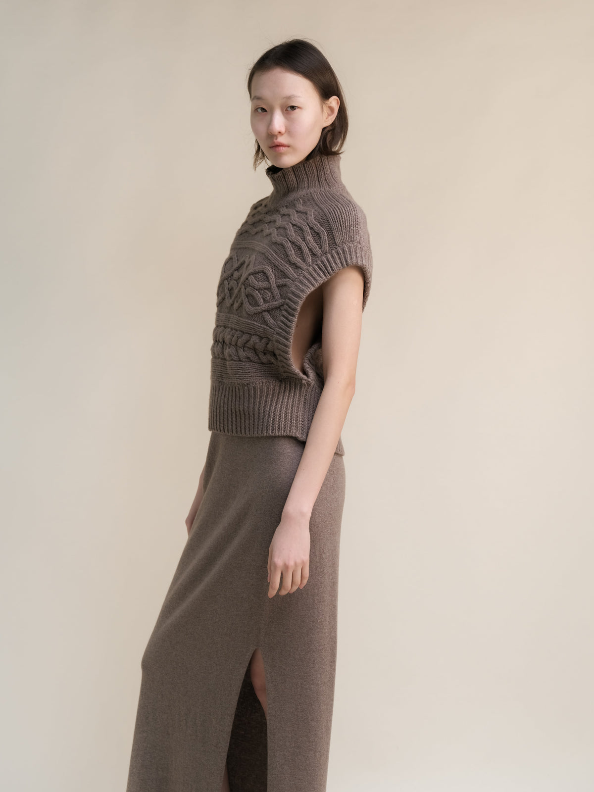 Taupe cashmere mix maxi tunica a trecce worn by a model con a collo alto e sleeveless oversized armholes