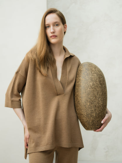 Femme portant camel maxi polo oversize en mérinos with a collar and 3/4 sleeves.