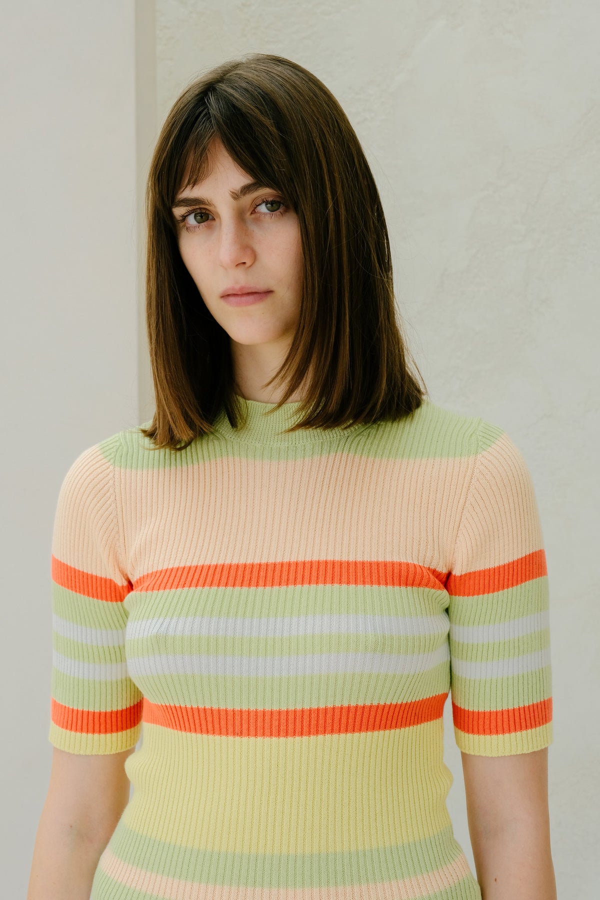 Mulher com a colorful striped sweater against a plain background