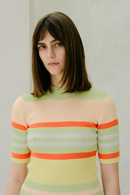 Mulher com a colorful striped sweater against a plain background
