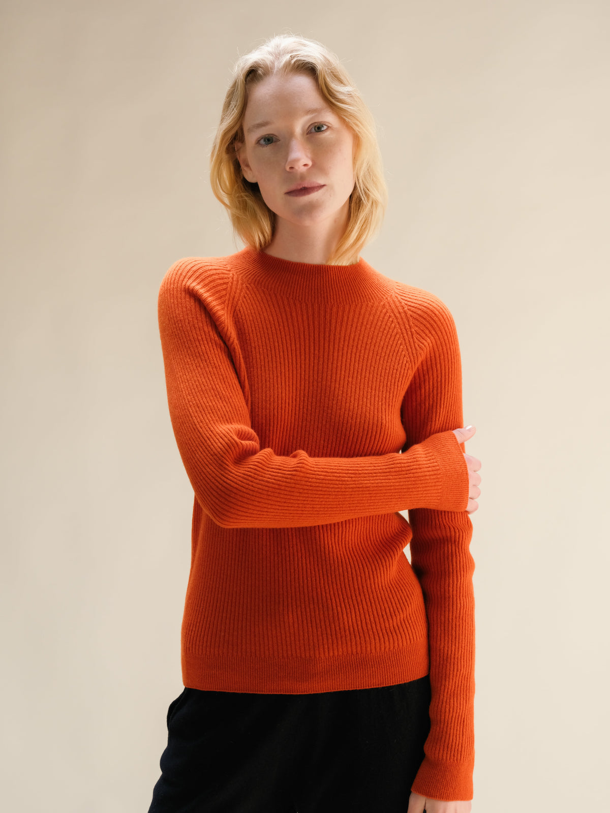 Modella con a bright arancione ribbed cashmere mix mock neck sweater.