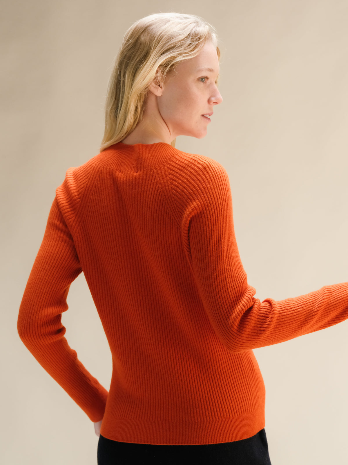 Vista posteriore di una maglia a collo alto corto in misto cashmere arancione acceso a coste