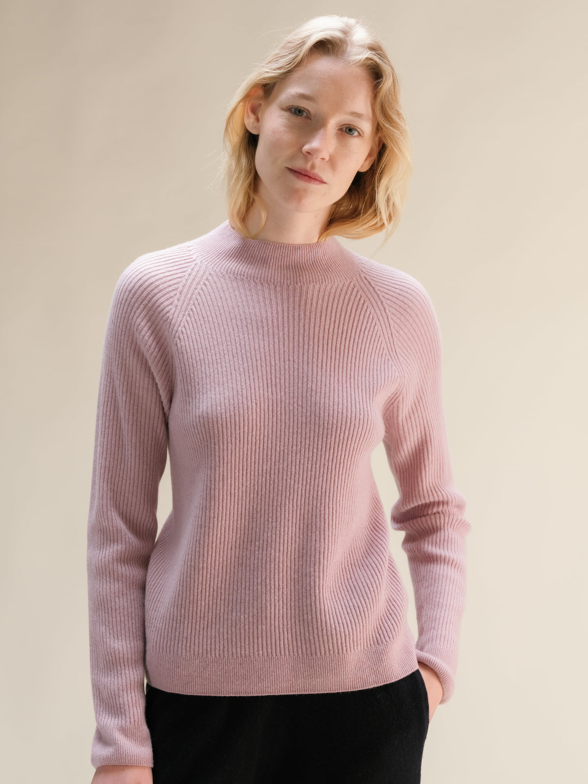 Rosa tenue cashmere mix maglione a coste con collo alto on a model.