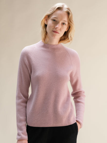 Rosa tenue cashmere mix maglione a coste con collo alto on a model.