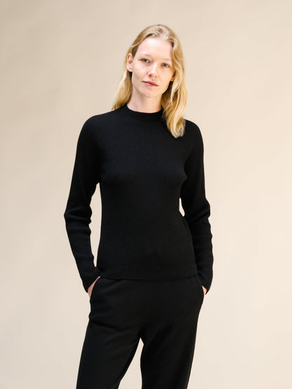 Modella con nero maglione a coste con collo alto con a texture in maglia 3D
