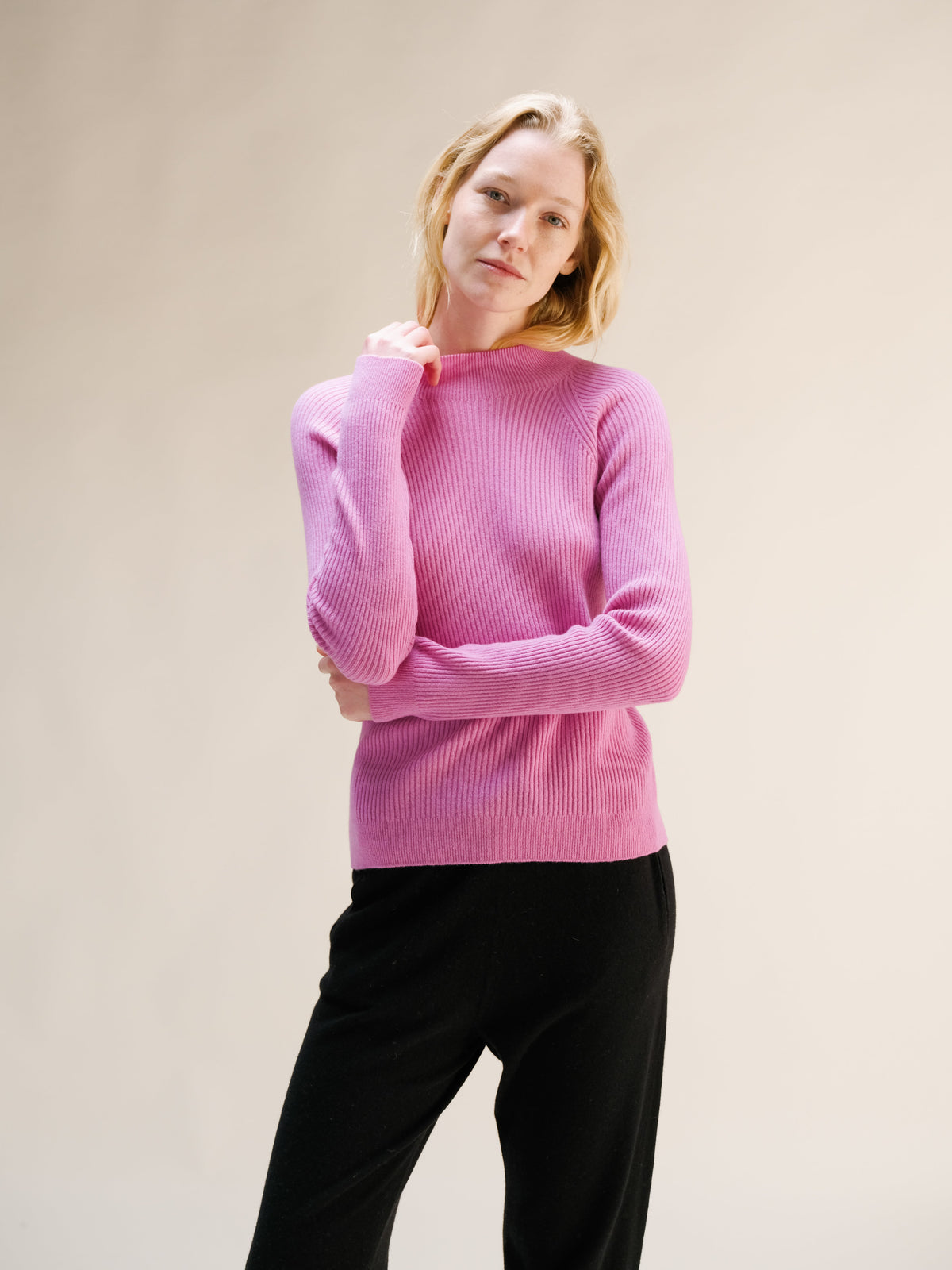 Modella con rosa maglione a coste con collo alto con texture morbida in maglia