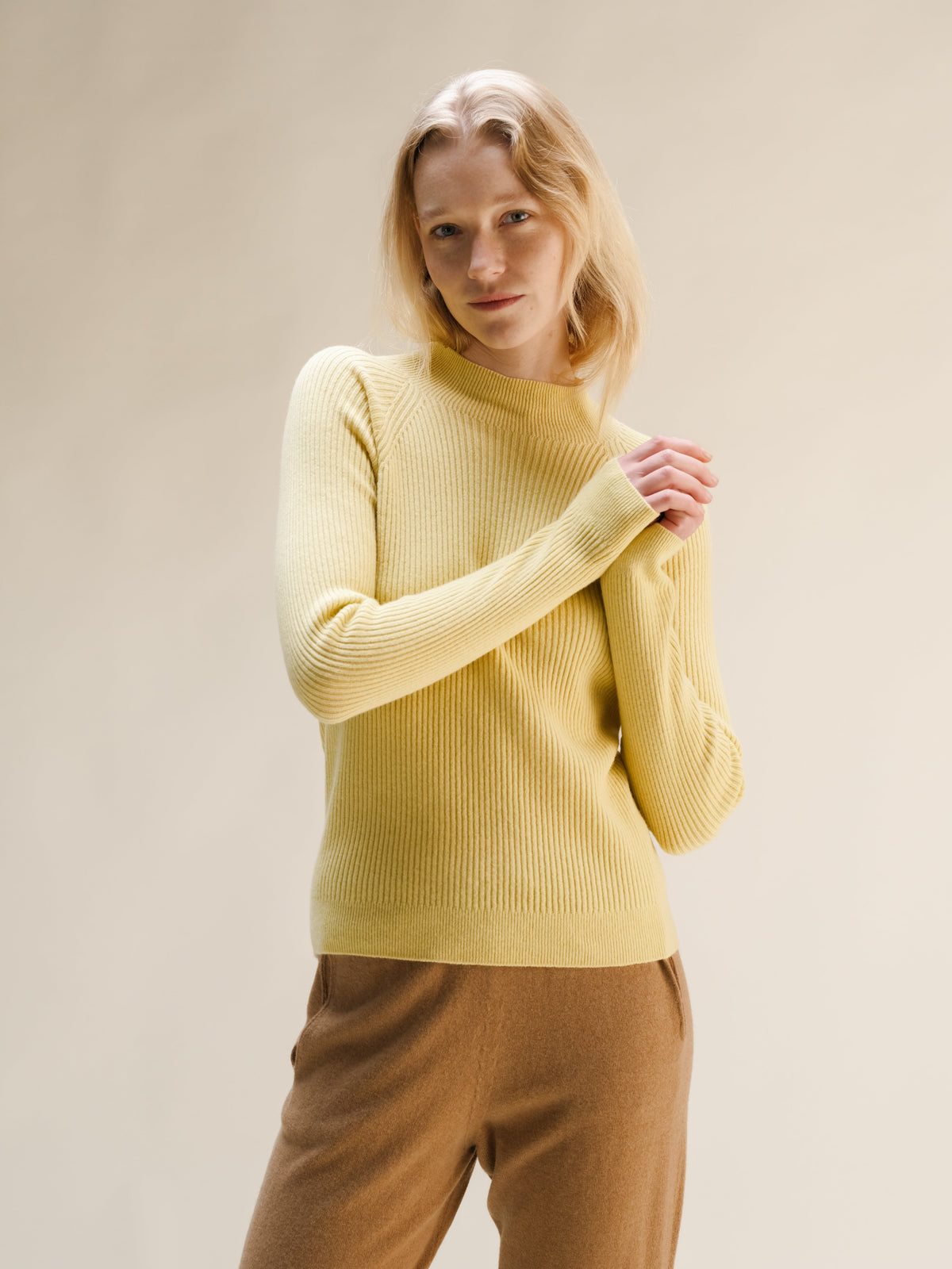 Modella con a pale yellow ribbed cashmere mix mock neck sweater con cuoio wide leg pants