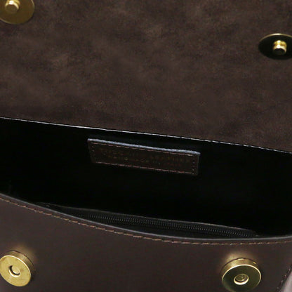 Close-up of a dark brown leather handbag interior showing a zippered pocket, a black interior lining, and brass-tone hardware.