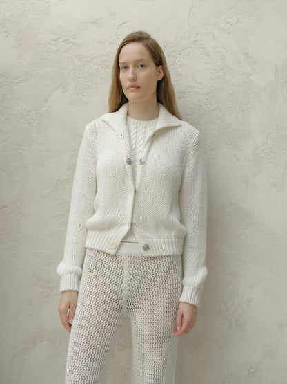 Front view of a model wearing a white textured knit bomber jacket with a collar and metal buttons.