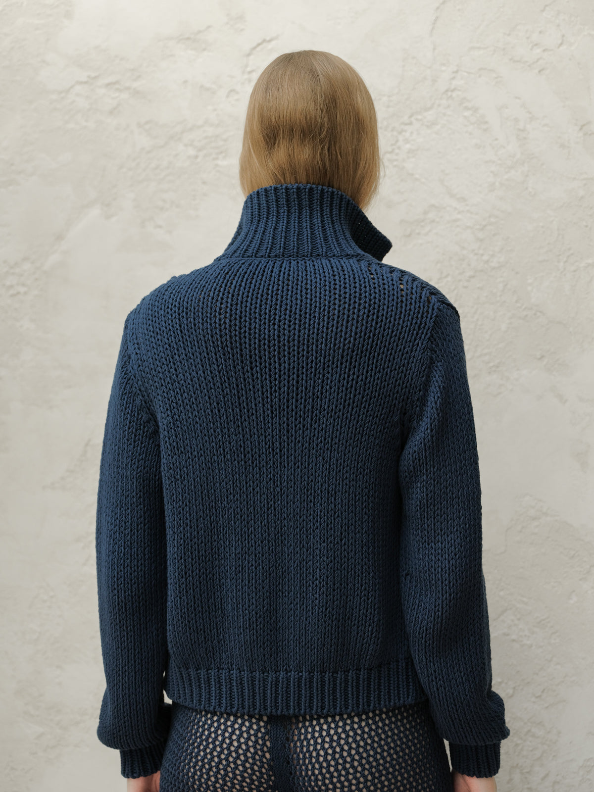 Back view of a model in a navy Fine Cotton Bomber Jacket with a tall ribbed collar