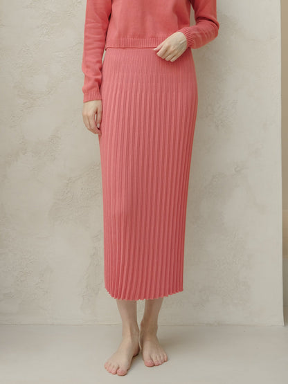 Persona con falda y jersey de punto acanalado rosa sobre fondo beige
