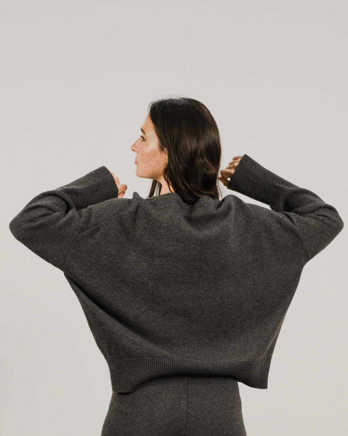 Back view of a modella con an oversized charcoal cashmere mix maglione girocollo