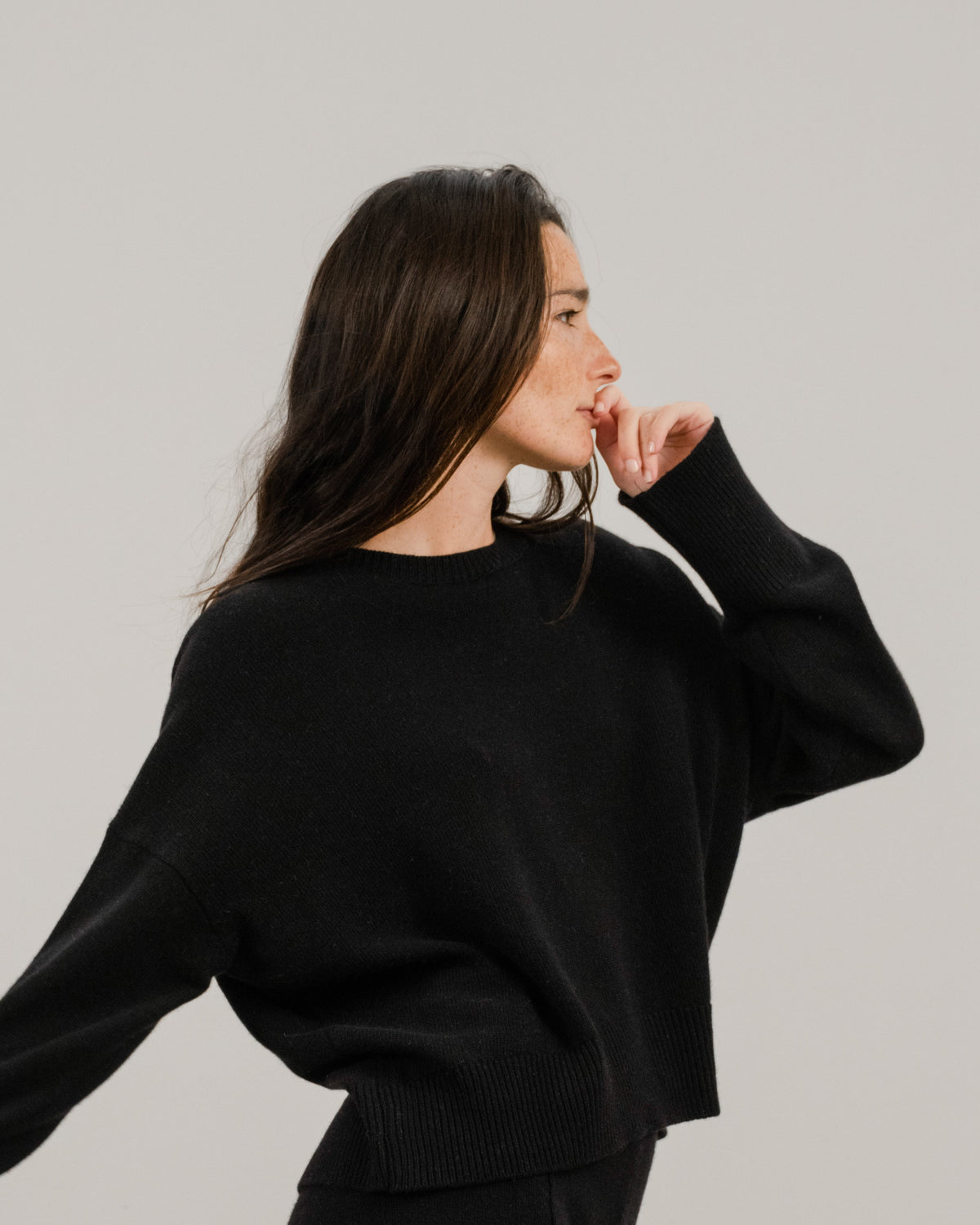 Side profile of a donna con a nero cropped cashmere mix maglione girocollo