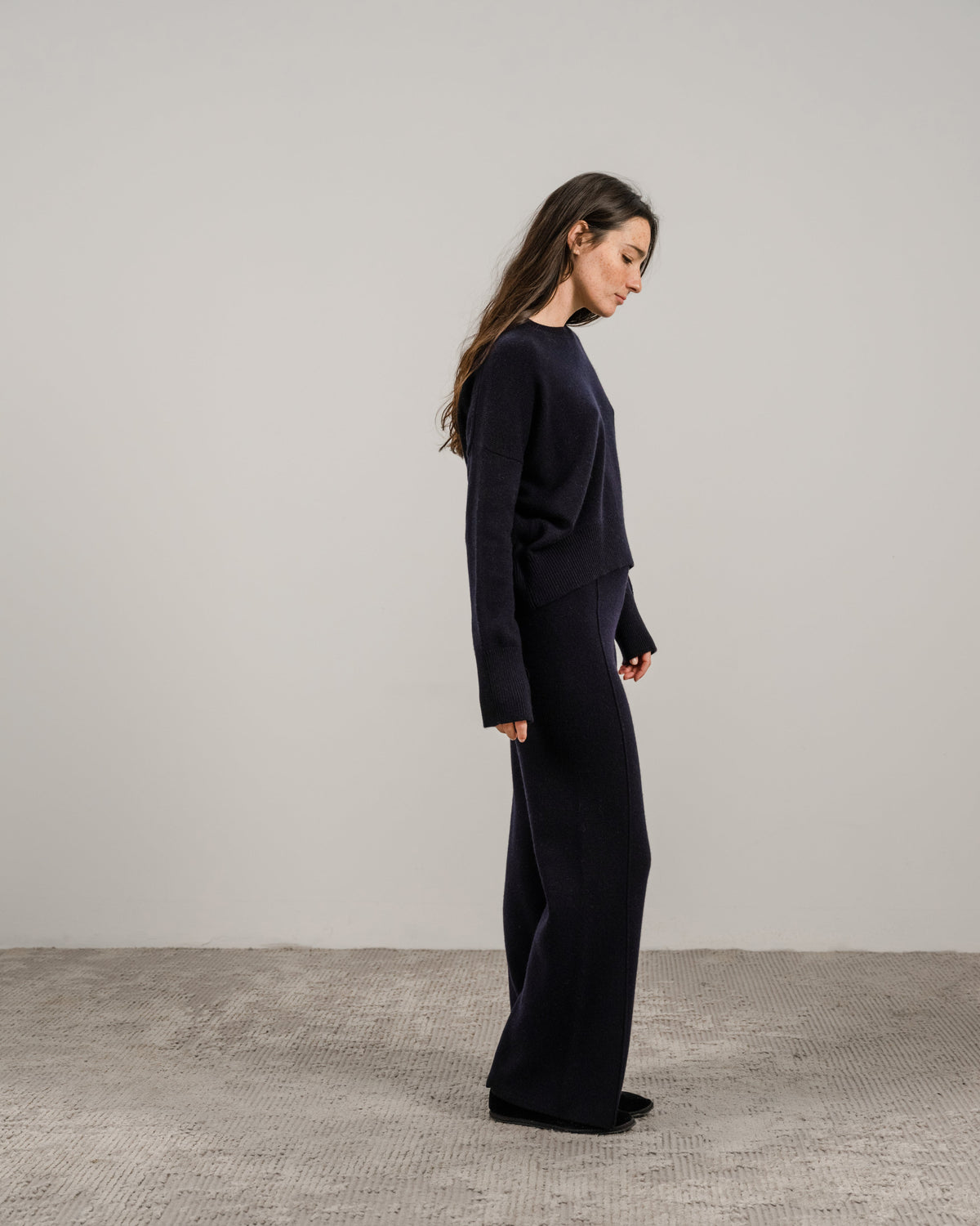 Side profile of a model in navy cashmere mix maglione girocollo e pantaloni coordinati a gamba larga