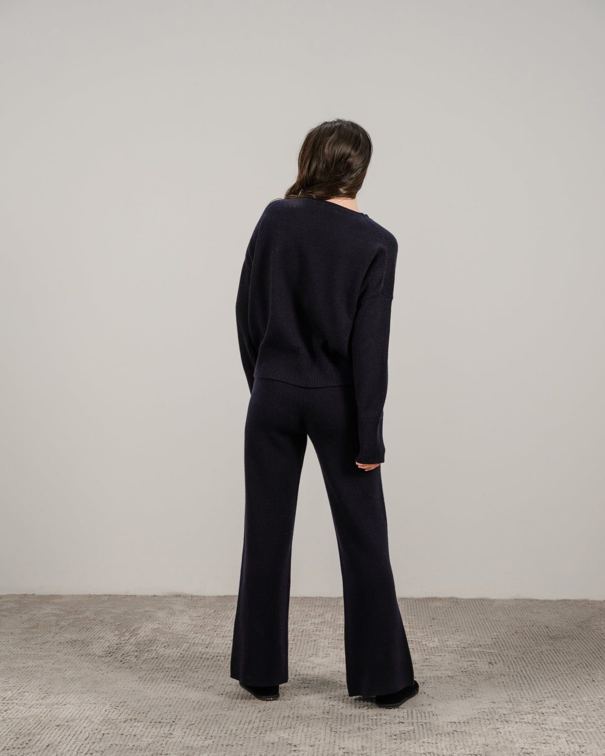Back view of a modella con navy cashmere mix maglione girocollo con pantaloni coordinati a gamba larga