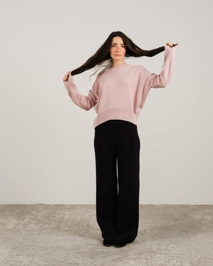 Modella con a soft rosa cashmere mix maglione girocollo con nero pantaloni a gamba larga.