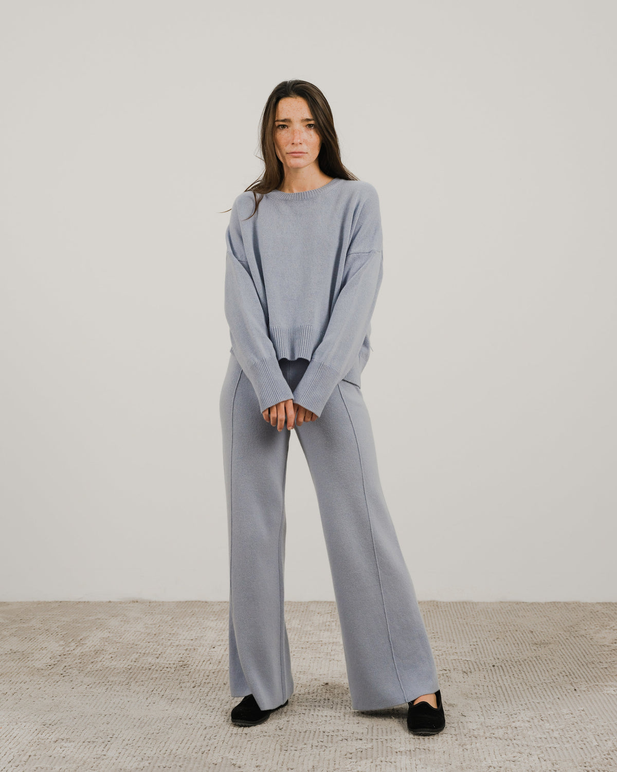 Full-body vista frontale of a modella con a light blu cashmere mix maglione girocollo con pantaloni coordinati a gamba larga