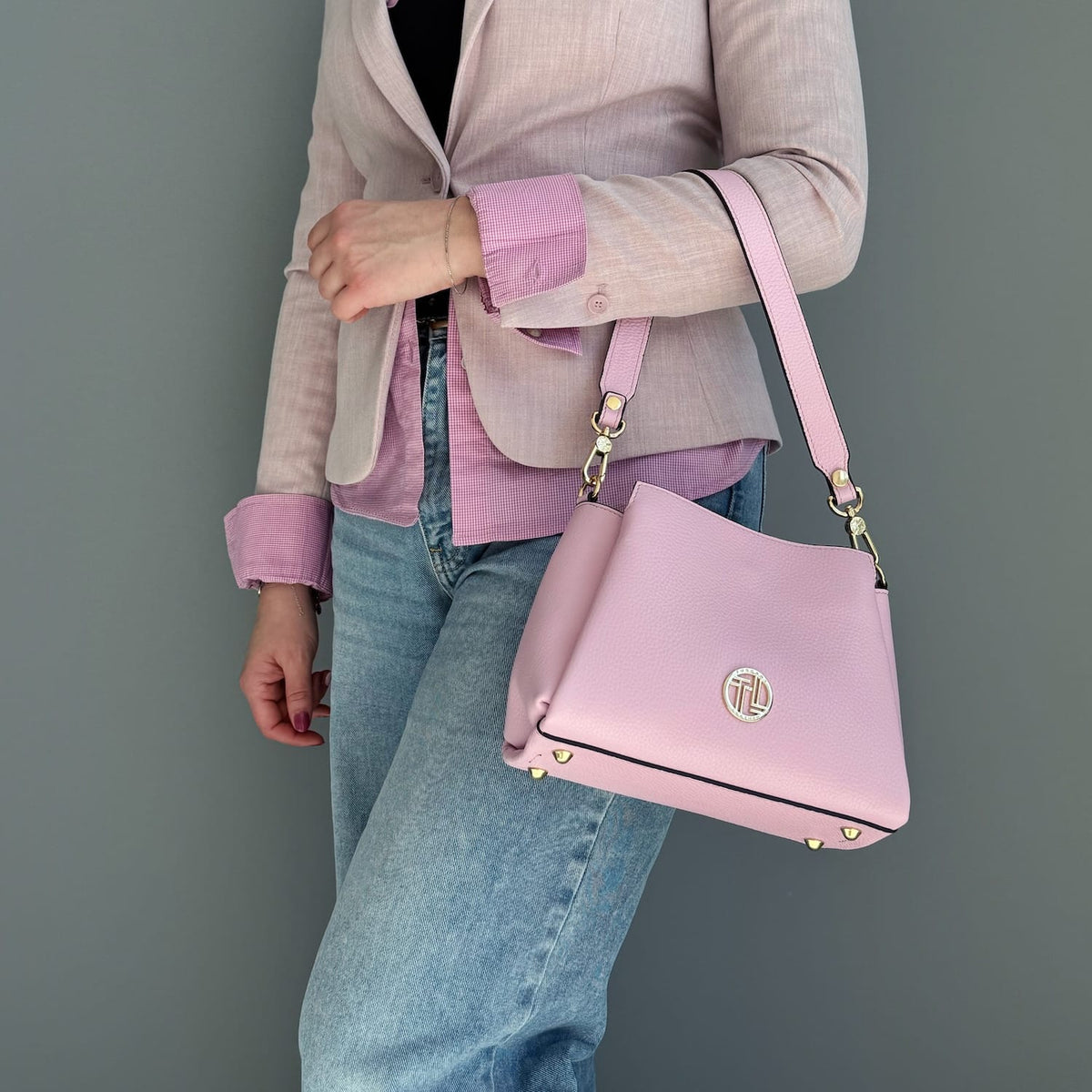 Rosa leather Abby shoulder bag with goldfarbenes Emblem on front and chain strap.