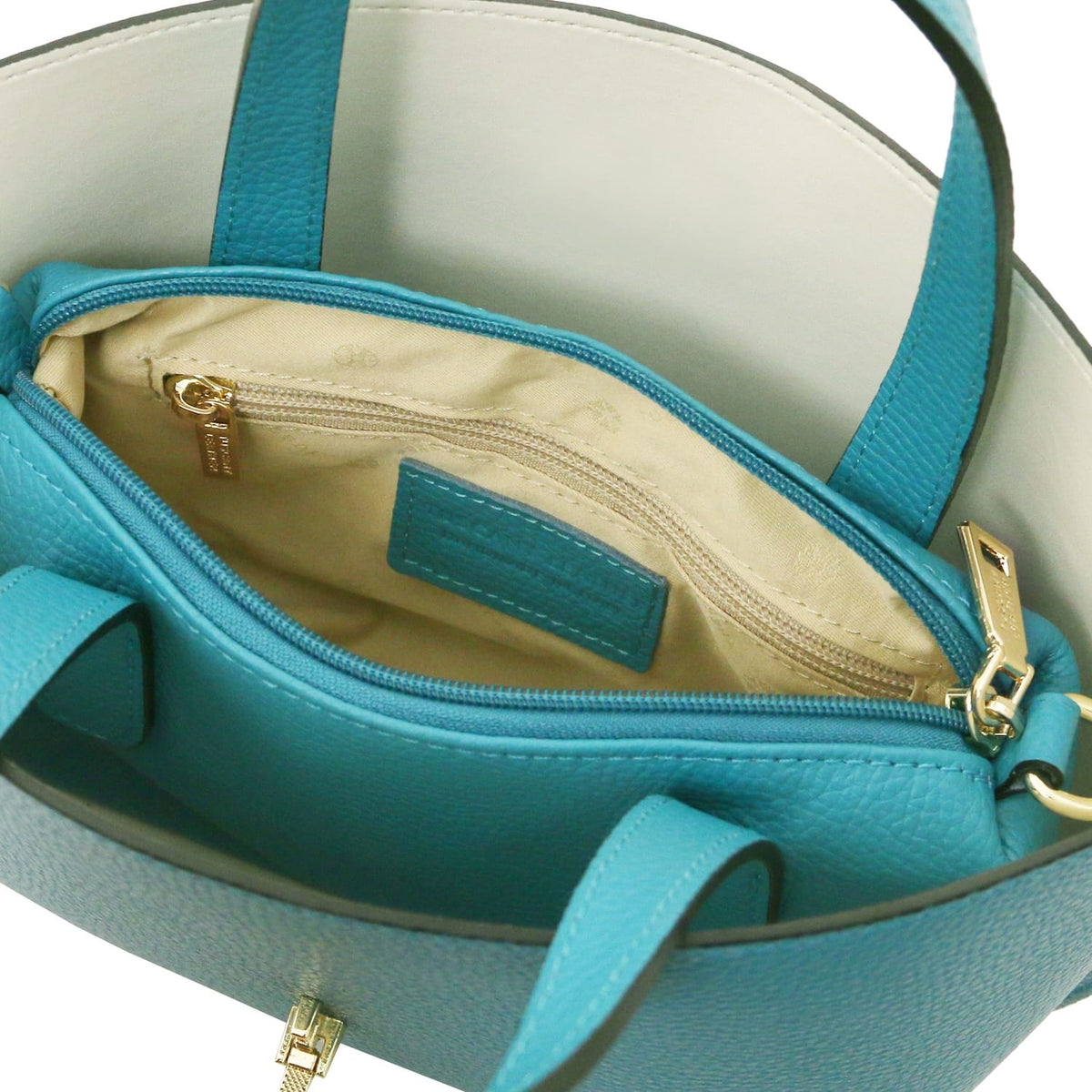 Top view of turquoise leather tote with beige fabric interior and zipped inner pocket featuring gold zipper pull.