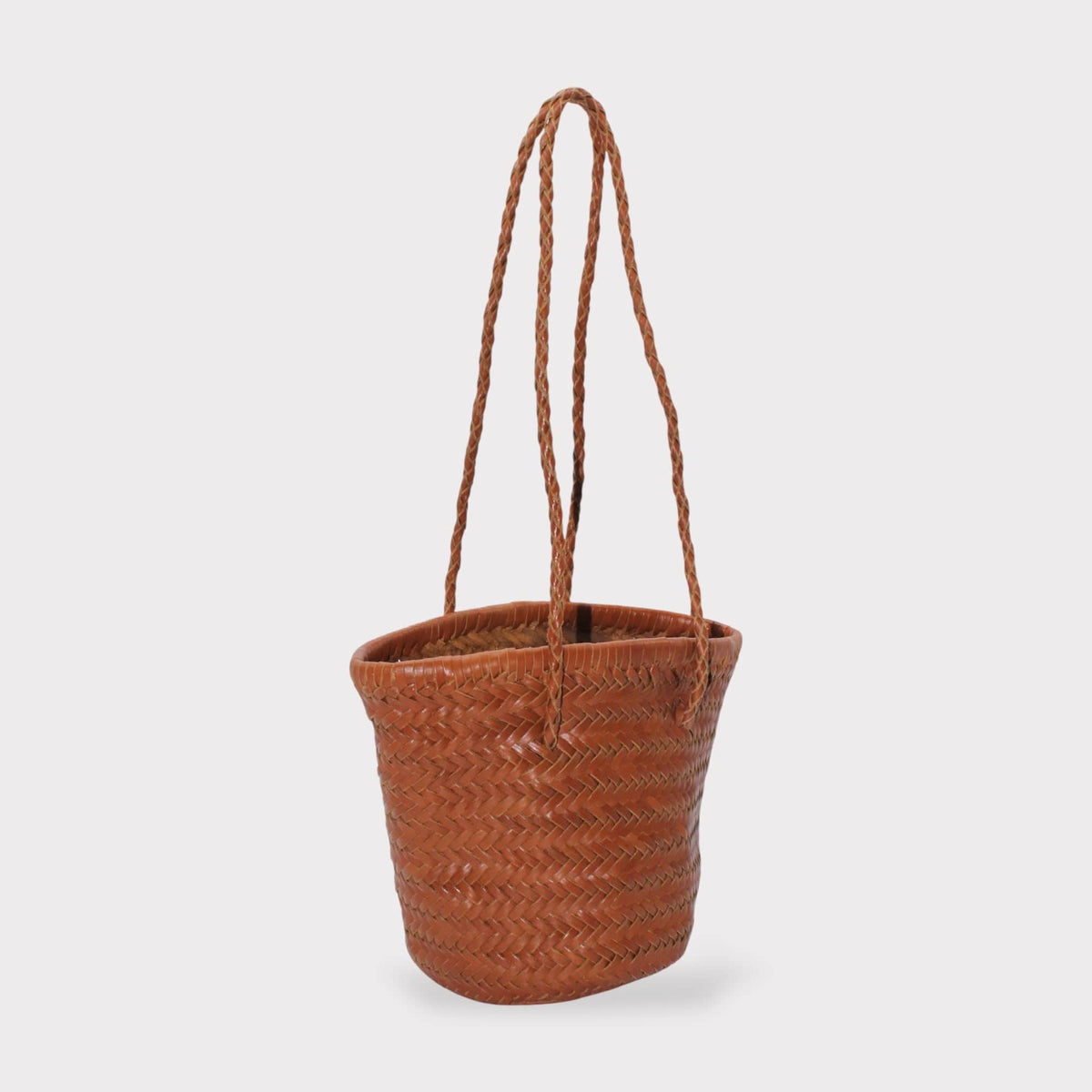 Carmel hand woven brown leather shoulder bucket bag shown in zijaanzicht with braided handles.