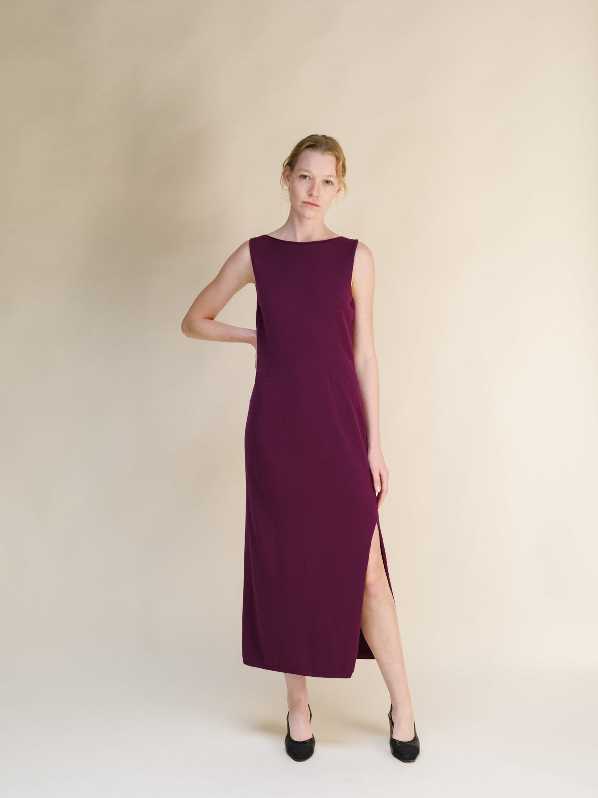 Full-length modelo con a burgundy cashmere blend boat neck sleeveless dress with a abertura lateral