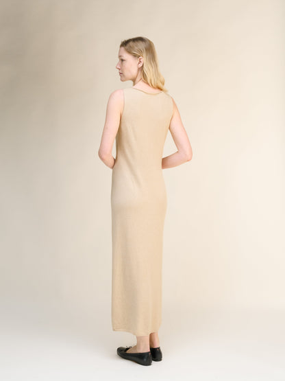 Back view of beige cashmere blend boat neck sleeveless dress on a model with a abertura lateral