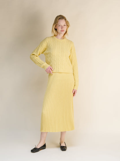 Modelo con amarillo pálido cashmere blend 3D knit sweater with falda midi acanalada a juego and black flats