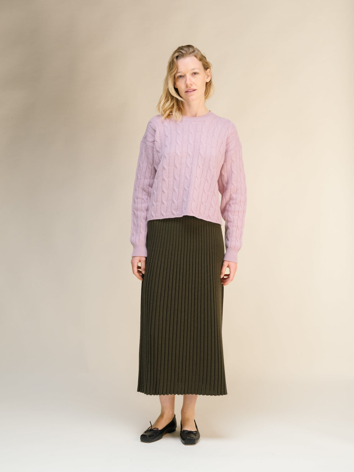 Modelo con a pink jersey de punto trenzado with a oliva oscuro falda midi acanalada from the cashmere blend 3D knit collection