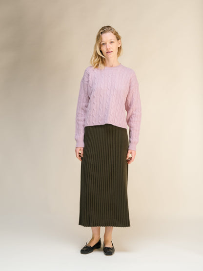 Modelo con a pink jersey de punto trenzado with a oliva oscuro falda midi acanalada from the cashmere blend 3D knit collection