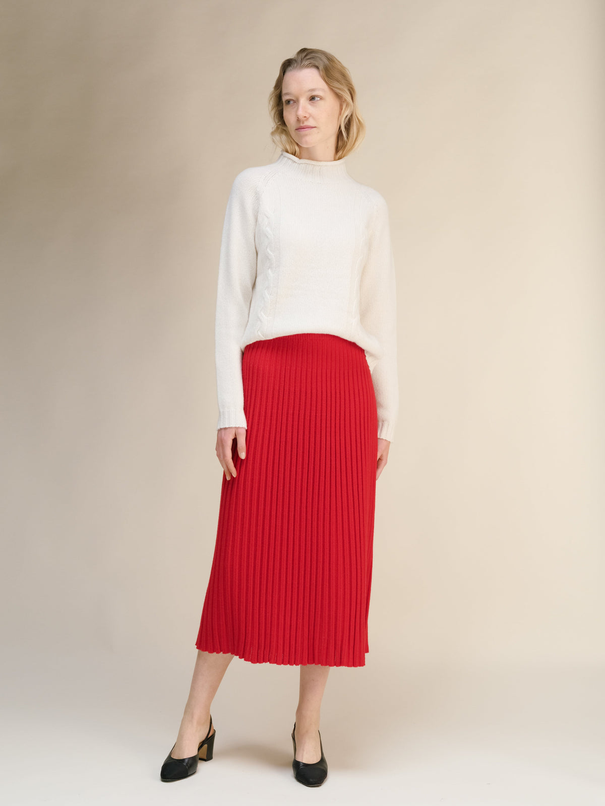 Modelo con a white knit sweater combinada con a rojo intenso knit falda midi with vertical ribbing