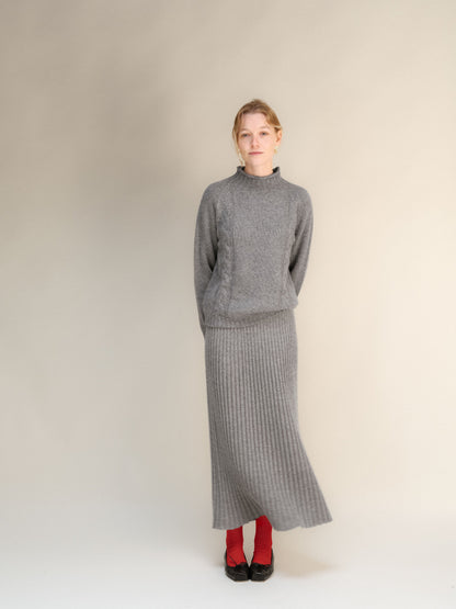 Modelo con gray cashmere blend 3D-knit falda maxi acanalada with a jersey a juego against a neutral backdrop