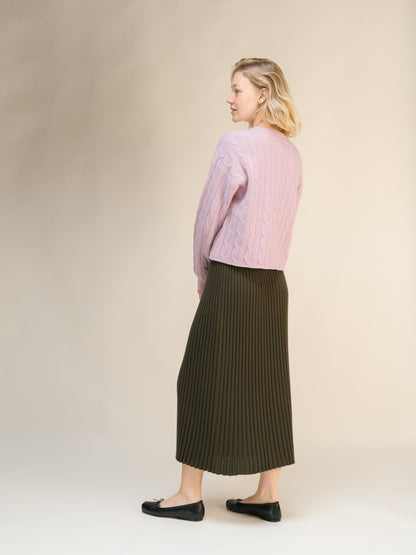 Vista lateral of a modelo con a pink knit sweater and olive falda midi acanalada