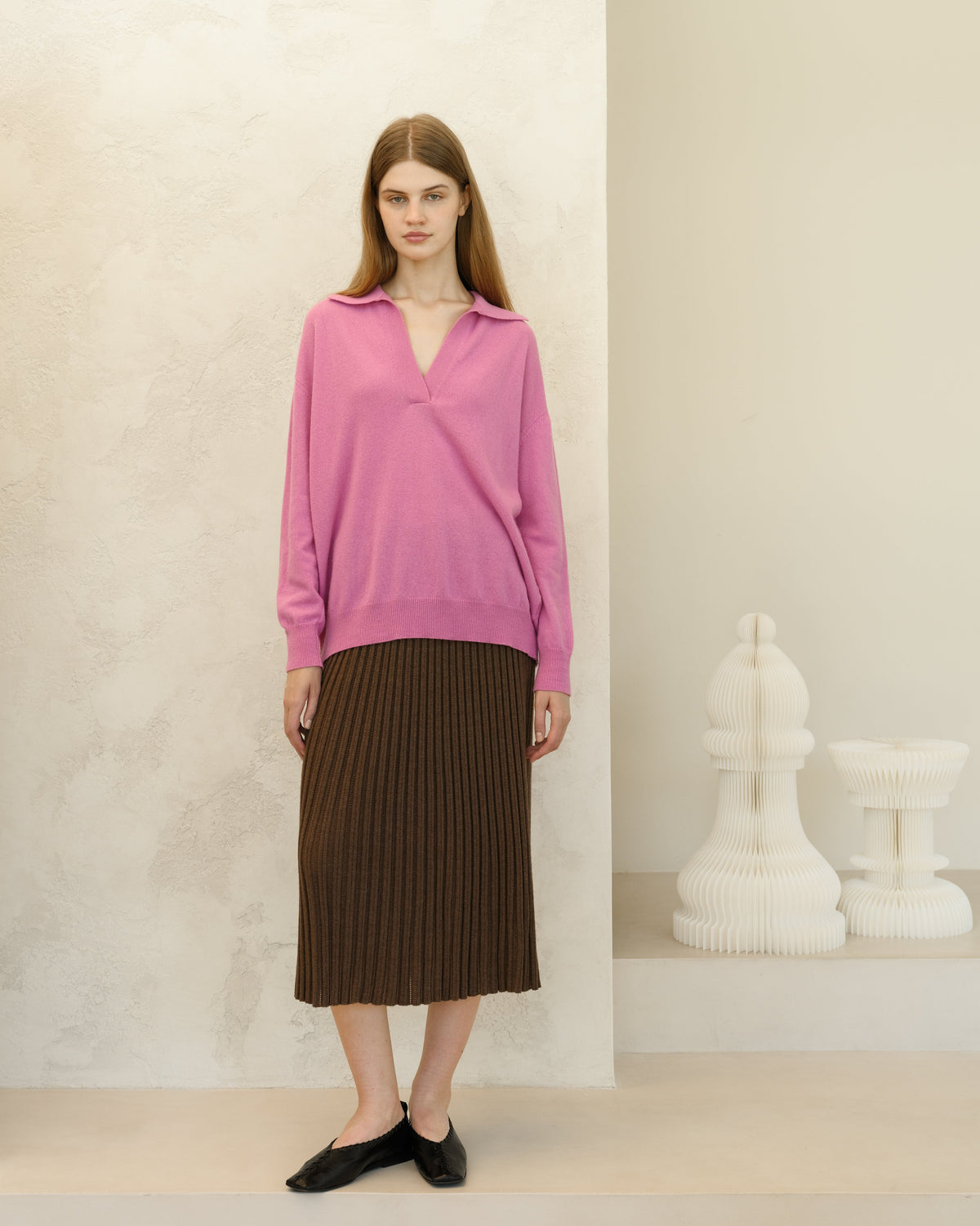 Modelo con pink oversized cashmere blend sweater combinada con a brown falda midi acanalada and black flats.