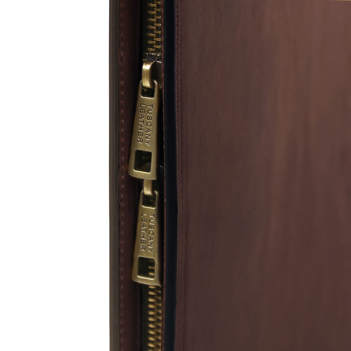 Close-up of brass zipper pulls along the edge of a brown leather Costantino document case