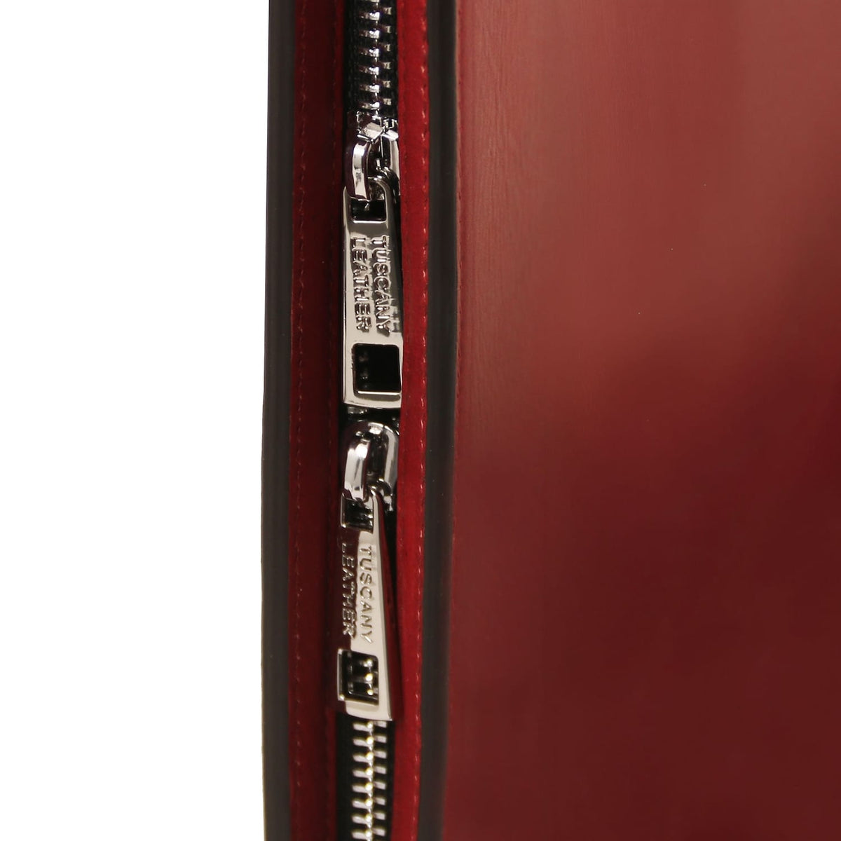 Close-up of the silver zipper along the red leather case.
