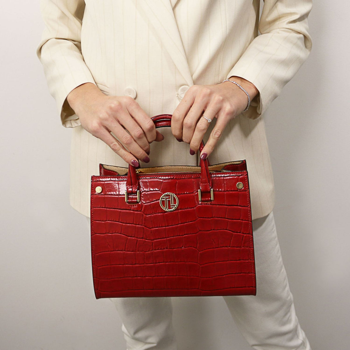 Croque - Bolso tote de piel con estampado de cocodrilo | TL142504 in glossy red with structured silhouette, asa superiors, and herrajes dorados held against neutral outfit.